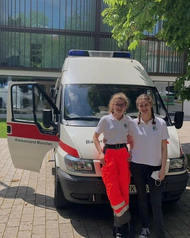 Zwei Helferinnen posieren vor dem Einsatzfahrzeug